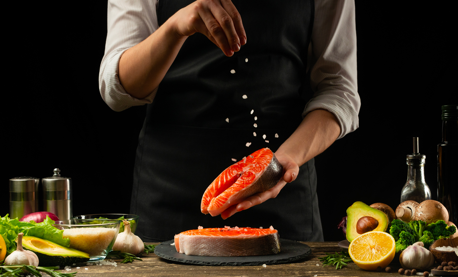 La photo met en scène un cuisinier préparant du saumon. Il s'agit de la photo principale de cet article rédigé par Eventdrive.