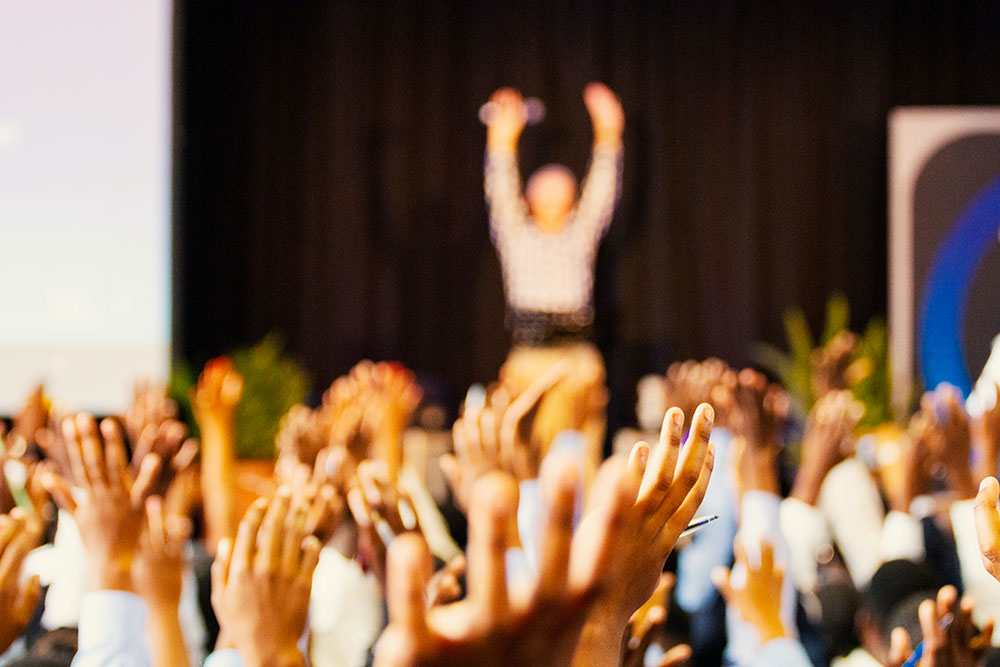 Un public levant les mains au ciel