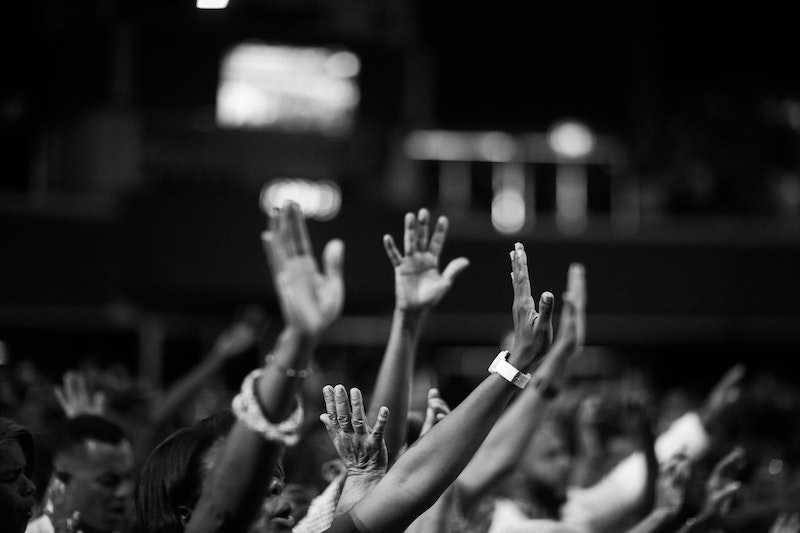 grayscale-photography-of-people-raising-hands-2014775