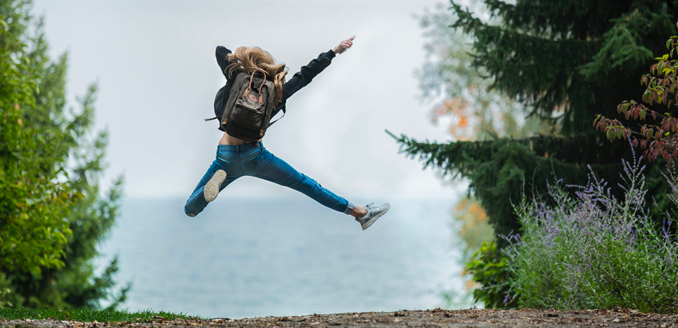 Une femme semblant faire de la randonnée saute de joie. Il s'agit de la photo principale de cet article rédigé par Eventdrive