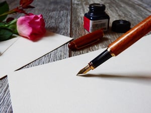 Un stylo plume est posé sur une feuille blanche. - Article de blog Eventdrive