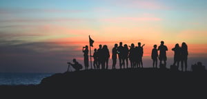 Un groupe de personnes regarde le coucher de soleil, l'air épanoui et détendu, profitant de l'instant. - Article de blog Eventdrive