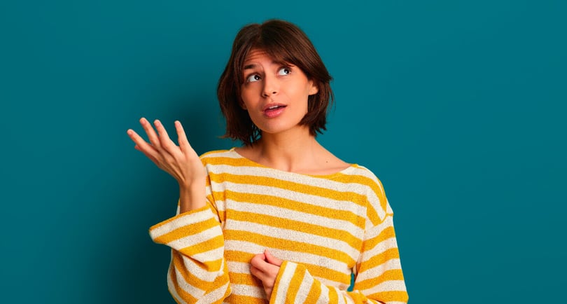 uncertain-young-ethnic-woman-looking-up-thoughtfully-blue-studio-(1)