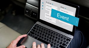 Homme utilisant un logiciel événementiel sur ordinateur portable avec une to-do list d’organisation d’événements professionnels