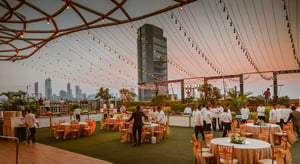 Rooftop événementiel au coucher du soleil, décoré de guirlandes lumineuses, prêt à accueillir un événement d’entreprise avec 2000 invités en extérieur - Article de blog Eventdrive
