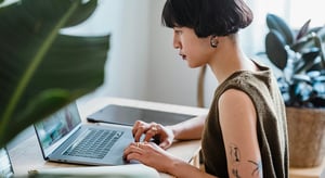 Une professionnelle concentrée sur son ordinateur portable. Cette image illustre l'importance d'une interface web événementielle soignée dans l’expérience participant. - Article de blog Eventdrive