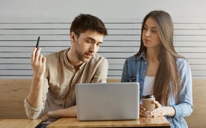 Deux collègues assis à une table de café, regardant un ordinateur portable ensemble lors d'une session de travail en équipe - Article de blog Eventdrive