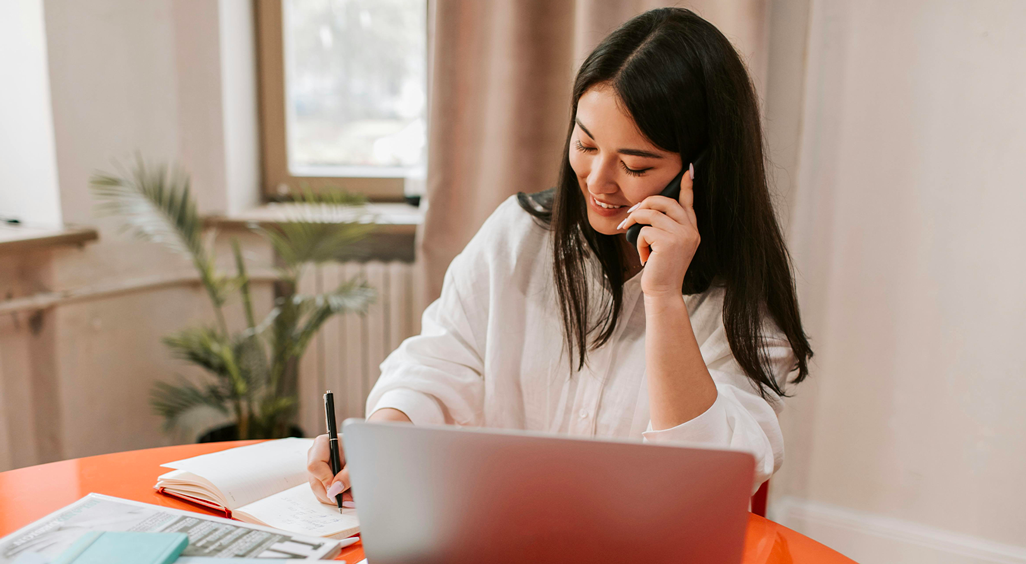 Event manager en pleine organisation d’un événement, au téléphone et devant son ordinateur, souriante et concentrée. - Article de blog Eventdrive
