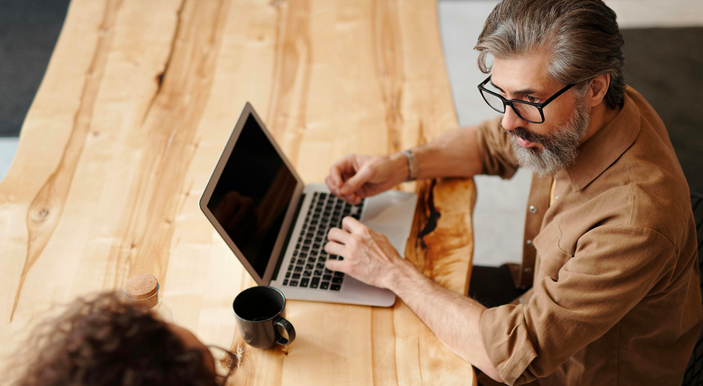 Homme travaillant sur un ordinateur portable dans un espace de coworking, illustrant l’utilisation d’un Event Management Software pour planifier un événement professionnel. - Article de blog Eventdrive