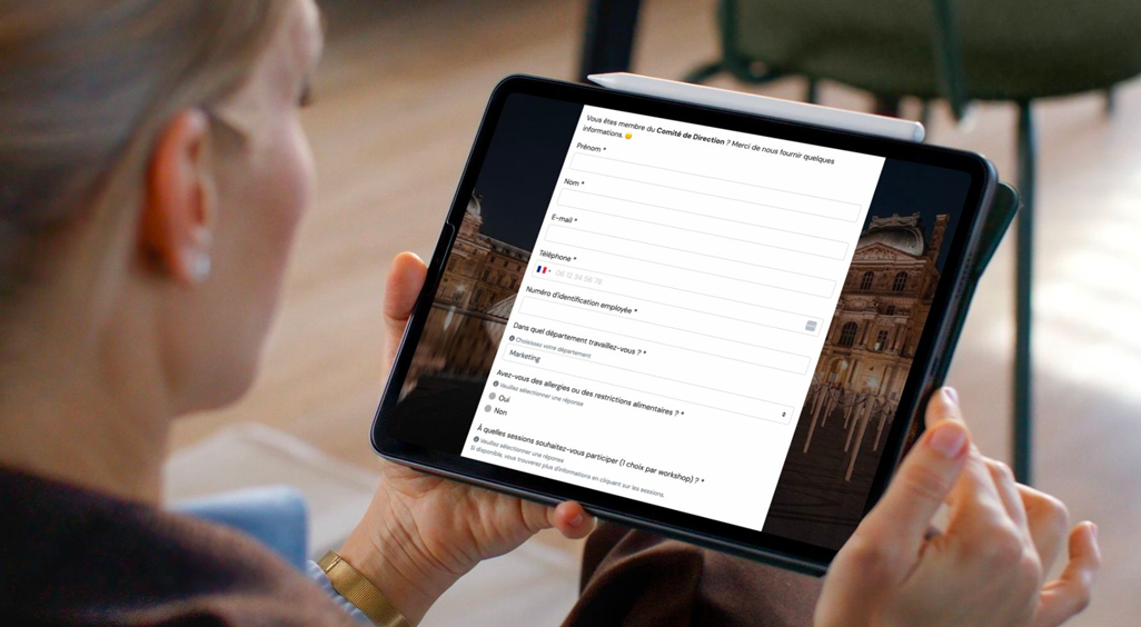 Femme consultant un formulaire d’inscription événementielle personnalisé sur tablette. L'image illustre l’importance de l’expérience digitale avant un événement. - Article de blog Eventdrive
