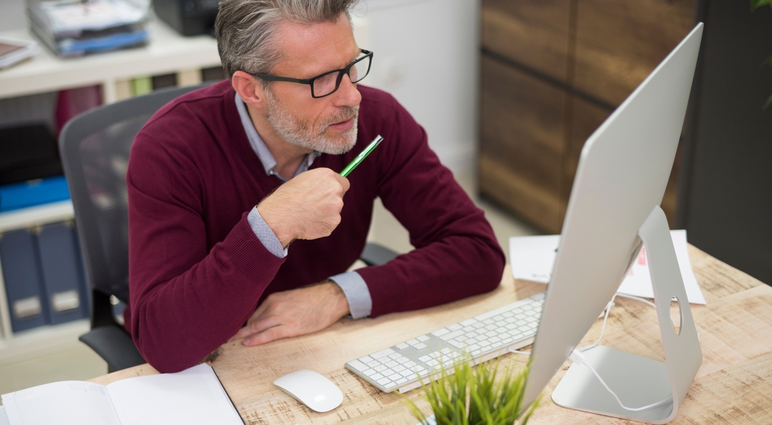 Homme assis à un bureau, travaillant sur un ordinateur dans un environnement professionnel. - Article de blog Eventdrive