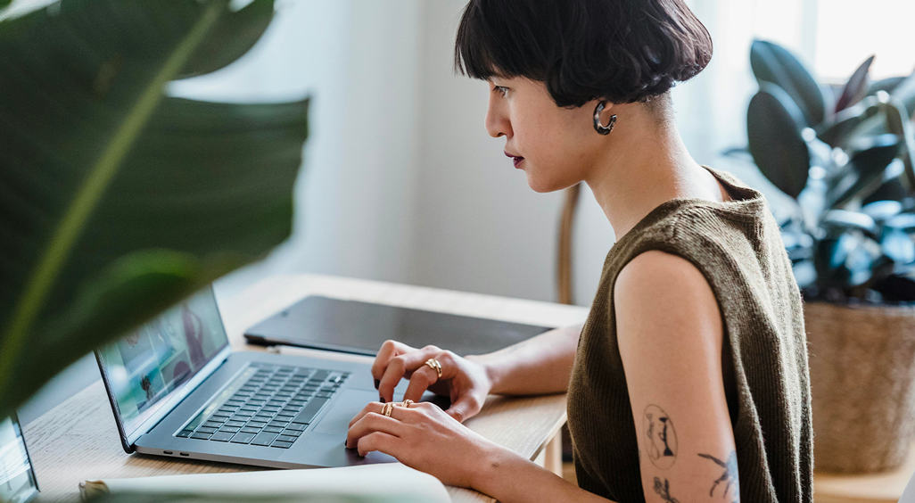 Une professionnelle concentrée sur son ordinateur portable. Cette image illustre l'importance d'une interface web événementielle soignée dans l’expérience participant. - Article de blog Eventdrive