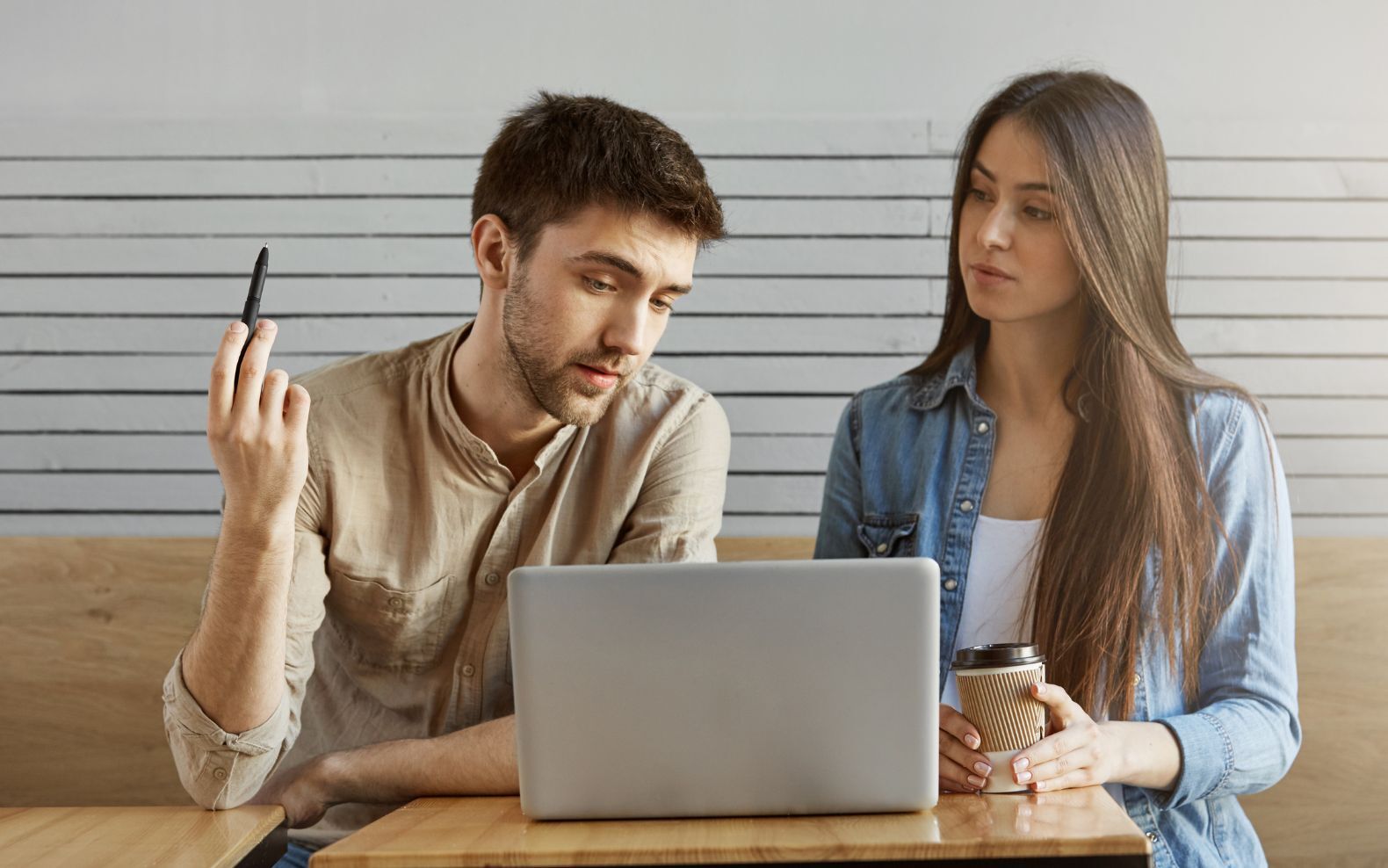 Deux collègues assis à une table de café, regardant un ordinateur portable ensemble lors d'une session de travail en équipe - Article de blog Eventdrive